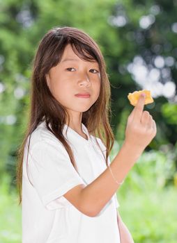 Asian girl holding biscuits in the park