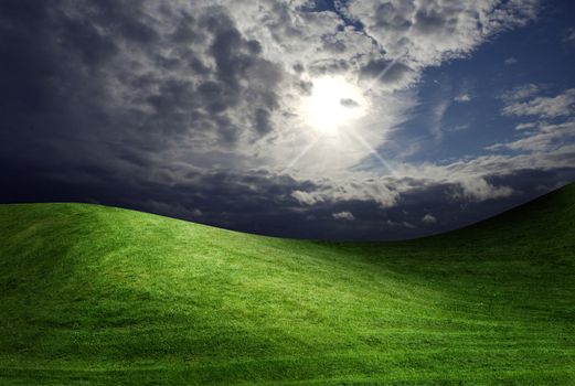dark cloudy sky and green grass meadow 
