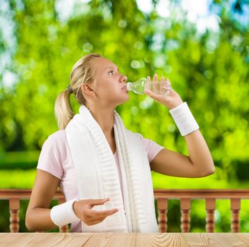 a girl drinking water from small bottle