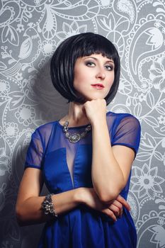 Beautiful young brunette woman shot in studio on a background of interior