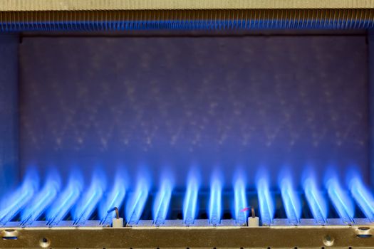 Blue flames of a gas burner inside of a boiler