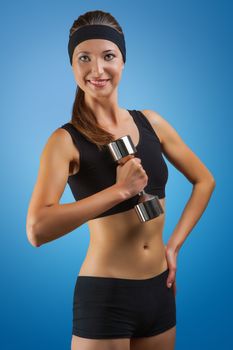 a sports girl posing with dumbbell