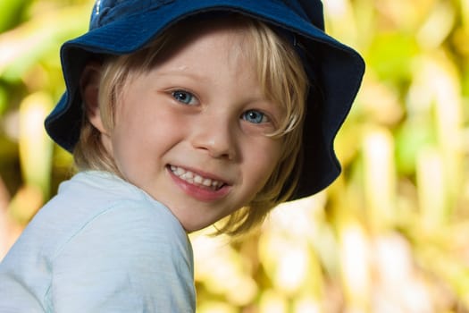 A close-up portrait of a cute young boy outdoors