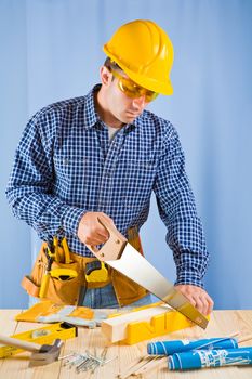 carpenter works with handsaw