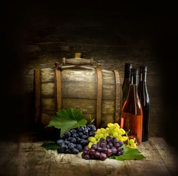 Still life with red and white wine, bottles, grapes and barrel