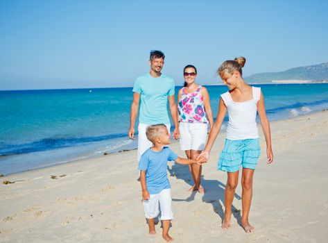 Family of four having fun on tropical beach