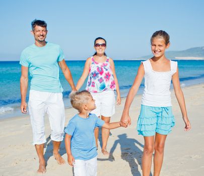 Family of four having fun on tropical beach