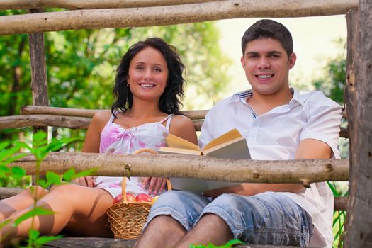 a couple resting on wooden bridge