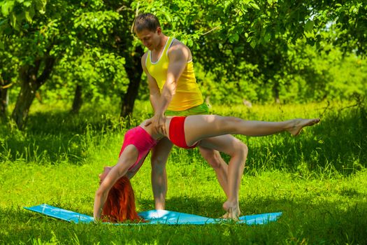 a men helping female do gimnastic