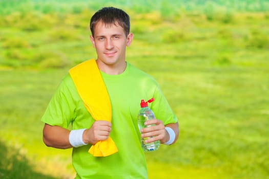 a sports man with towel holding bottle of water