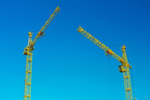 two construction cranes in sky