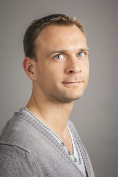 A handsome young man portrait in front of a grey background