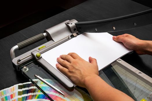 Man working on the guillotine for paper