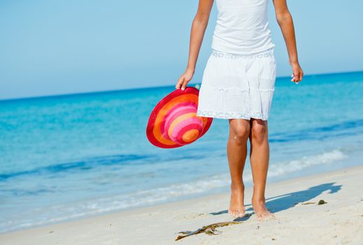 Walking on the beach. Close up on girl legs walking along the sea side.