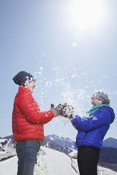 Two Young People Playing With Snow