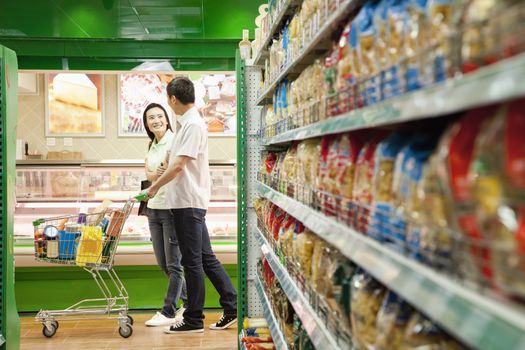 Man and Woman Shopping in a Supermarket with Shopping Cart