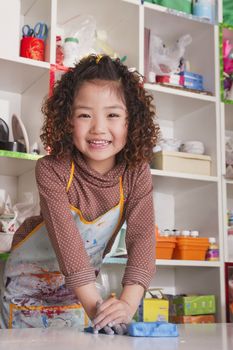 Girl Wearing Apron and Playing with Clay