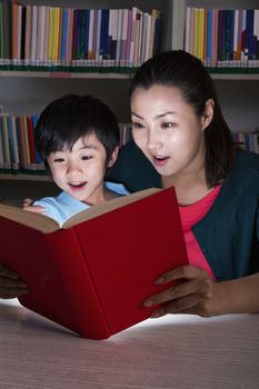 Boy and Teacher Surprised By Glowing Book