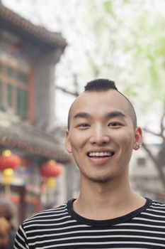 Young Man with Mohawk haircut smiling looking at camera