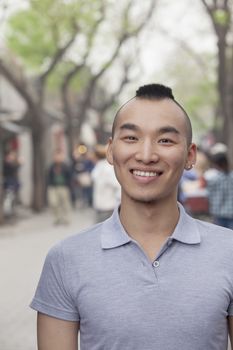 Young Man with Mohawk haircut smiling looking at camera