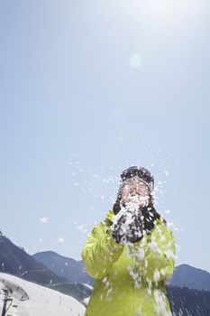 Young Woman Playing with Snow in the Mountains