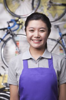 Portrait of young female mechanic in bicycle store, Beijing