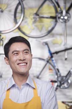 Portrait of young male mechanic in bicycle store, Beijing