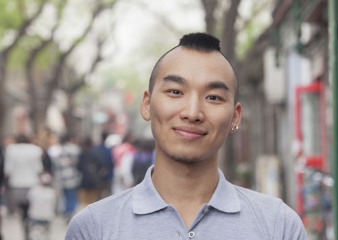 Young Man with Mohawk haircut smiling looking at camera