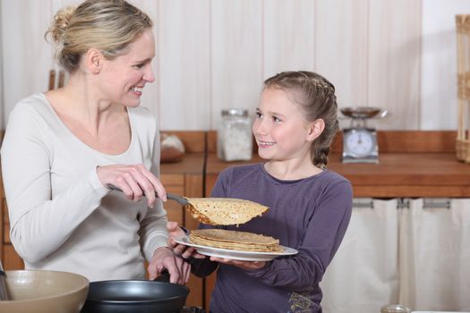 Little girl and mother about to eat pancakes for breakfast