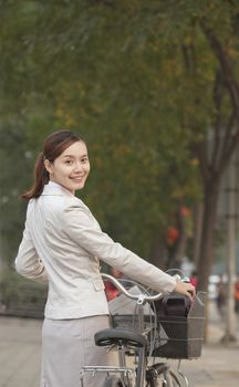 Young Business Woman standing with a Bicycle, Beijing, China