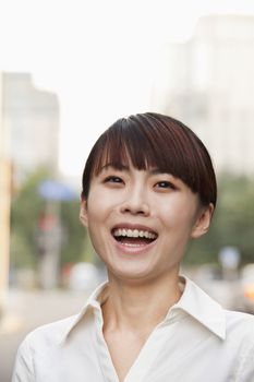 Portrait of young businesswoman laughing outside in Beijing 