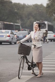 Young Business Woman standing with a Bicycle, Beijing, China