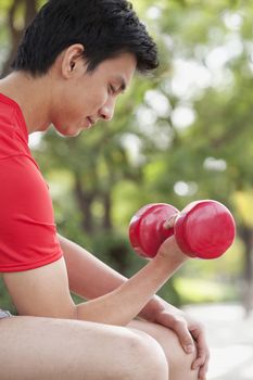 Young Man exercising with Dumbbell