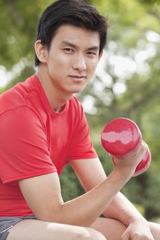 Young Man exercising with Dumbbell