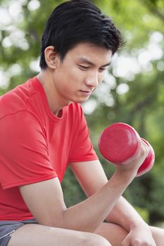 Young Man exercising with Dumbbell