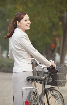 Young Business Woman standing with a Bicycle, Beijing, China