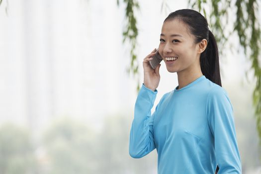 Young woman talking on cell phone in the park