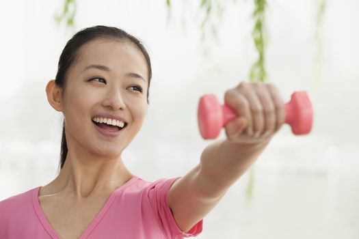 Young Woman Lifting Weights in the Park