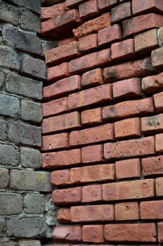 Two different color brick walls come together in an adjoining corner