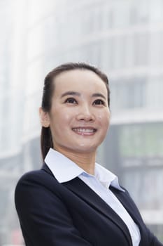 Young Businesswoman Smiling and Looking Up in Urban Setting