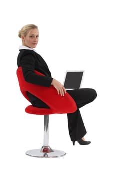 Woman sitting in a chair and using her laptop