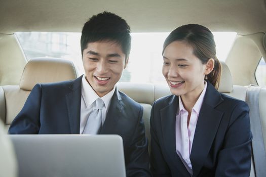 Business People Working in Back Seat of Car