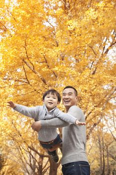 Father and Son Playing at Park in Autumn