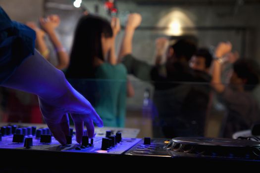 A view from DJ's deck of a crowd dancing in nightclub, 