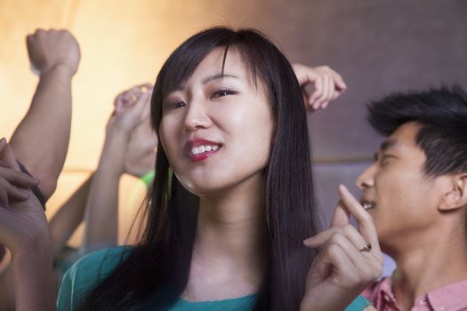 Portrait of a young woman dancing in nightclub