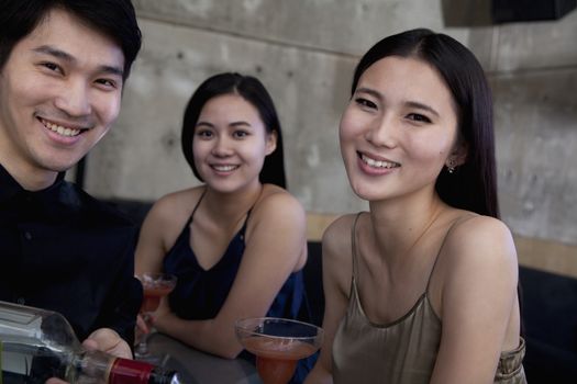 Portrait of young women and bartender at a bar