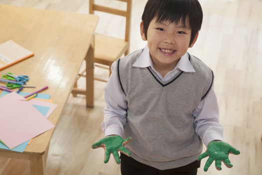 Portrait of smiling schoolboy finger painting in art class, Beijing