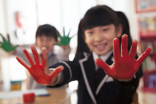 School children showing their hands covered in paint