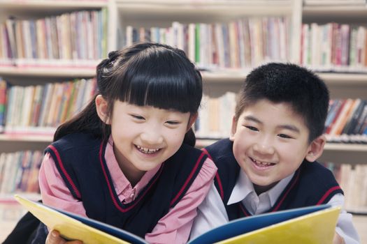 School children reading book a in the library