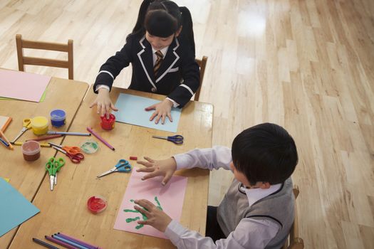 School children finger painting in art class, Beijing